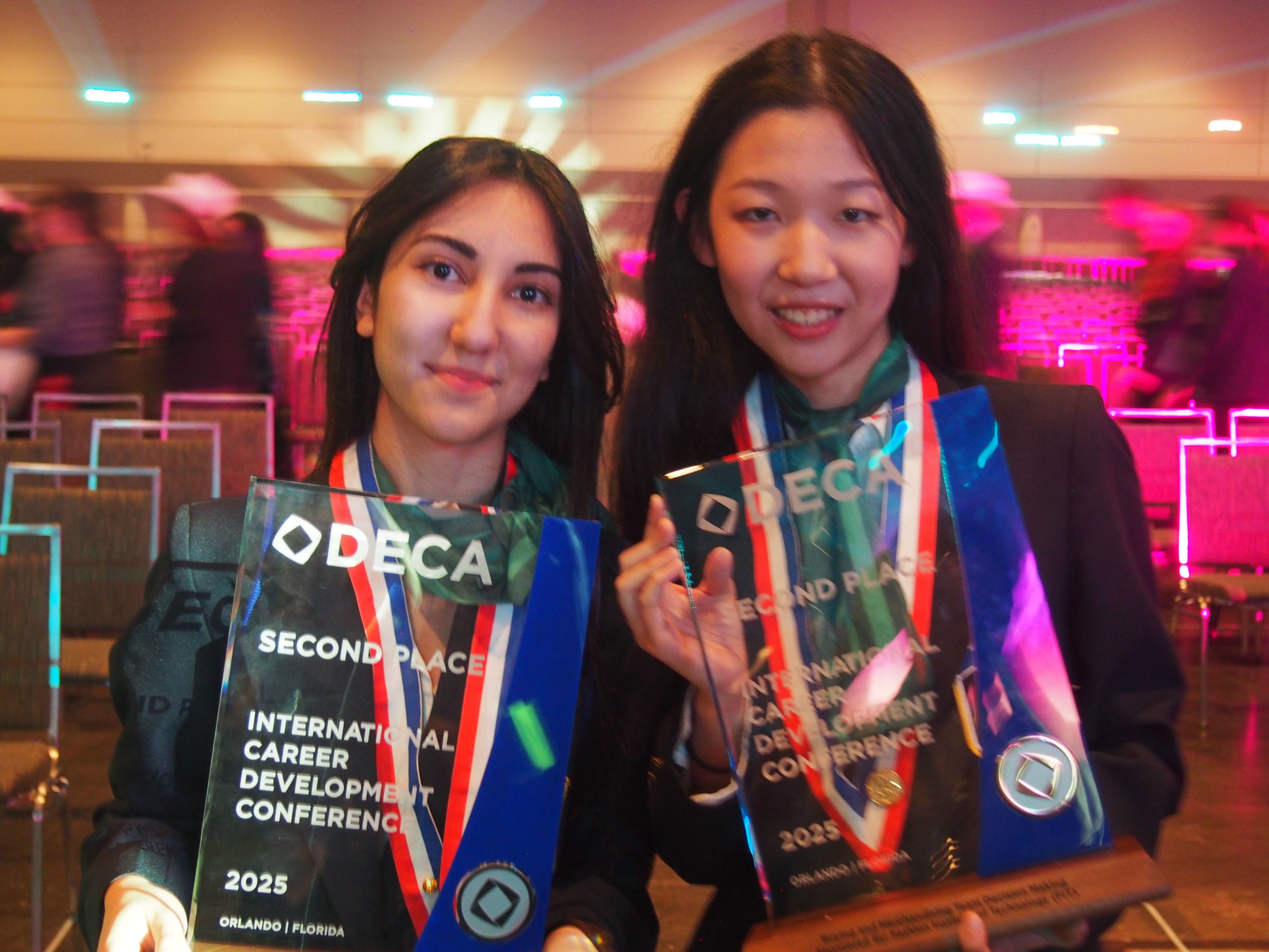 Two DECA students holding second place awards at an international conference.